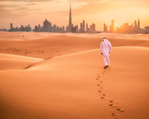 Arabic,Man,With,Traditional,Emirates,Clothes,Walking,In,The,Desert