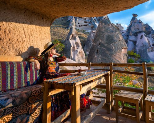Woman,In,Bohemian,Dress,Sitting,On,Traditional,Cave,House,In